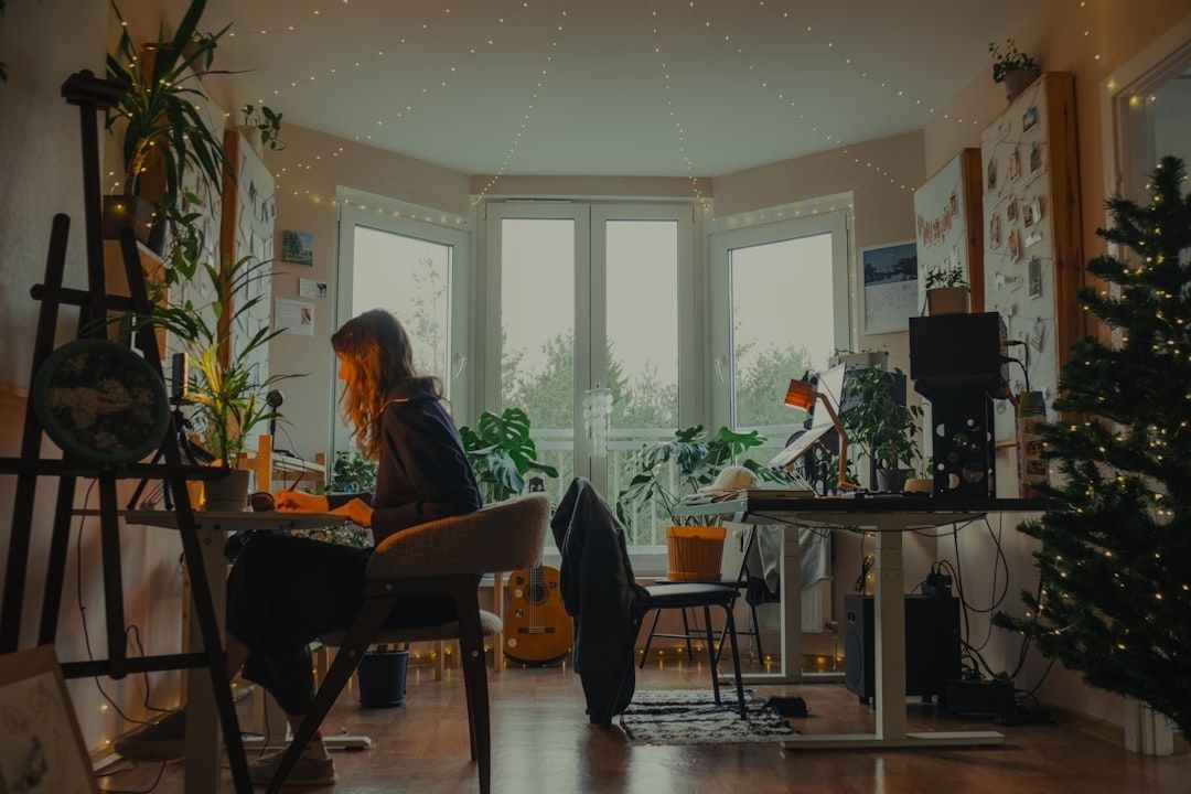 Person arbeider ved laptop i et hjemmekontor med dempet belysning