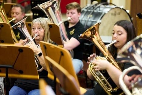 Brassband med musikere i ulike aldre under en felles øvelse